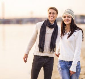 Loving young couple walk on the beach in autumn